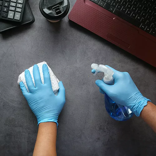 Person with blue gloves cleaning slate surface