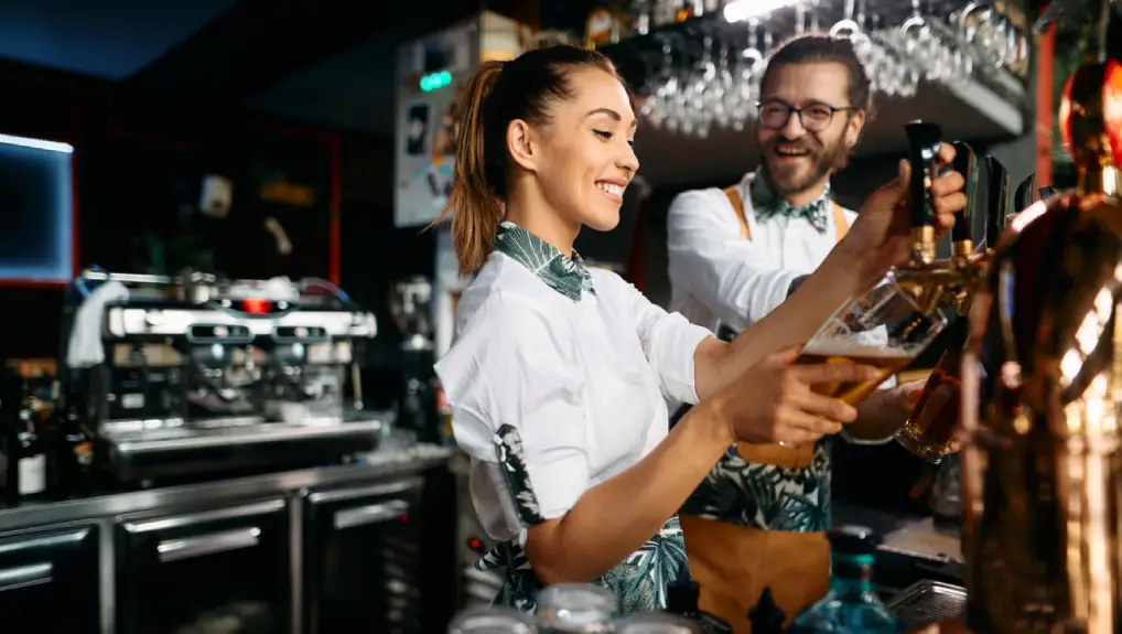 Image of bartender surrounded by essential bar equipment typical for a small business.