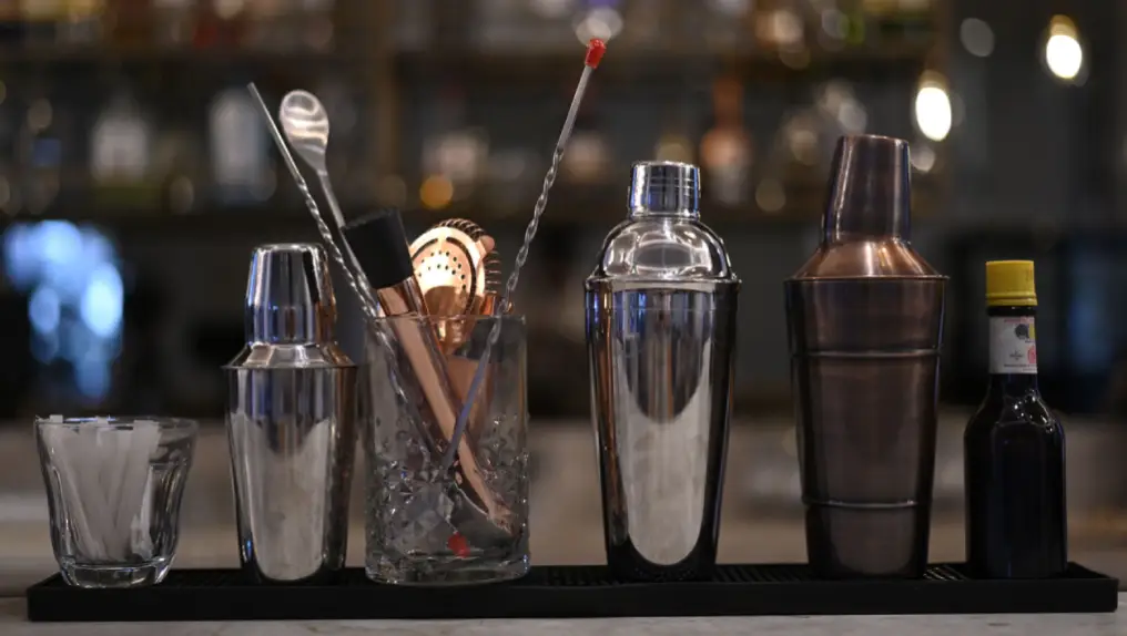 Close up image of various cocktail shakers and bar tools.