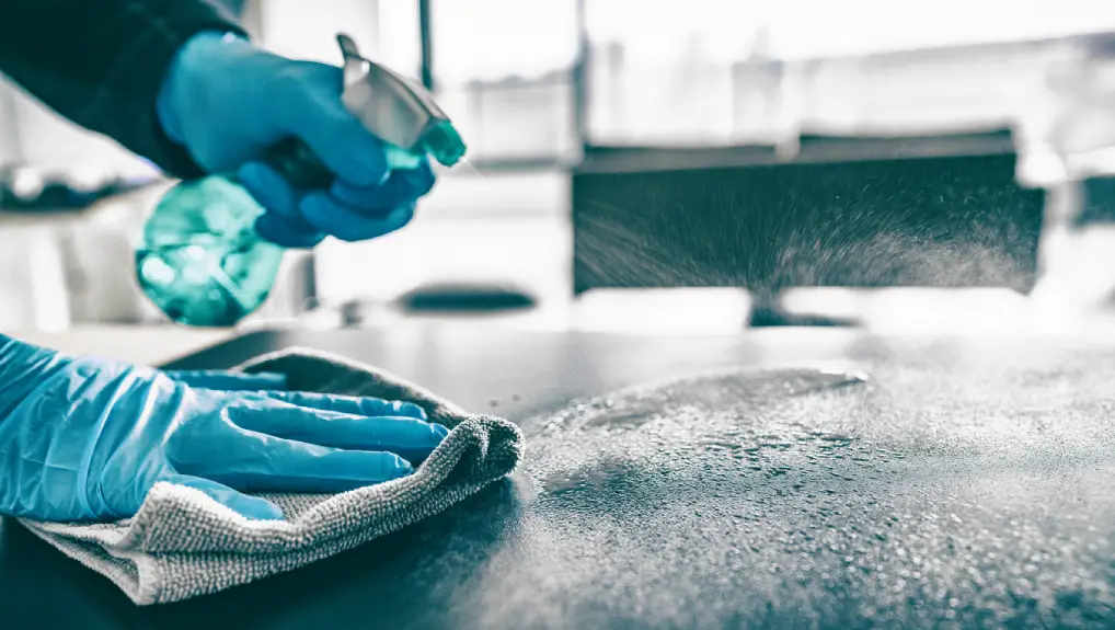 close up image of a bartender cleaning a bar surface part of the duties for an ultimate bar equipment guide for restaurants.