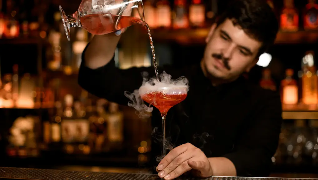 Image of a bartender mixing a cocktail in a bar