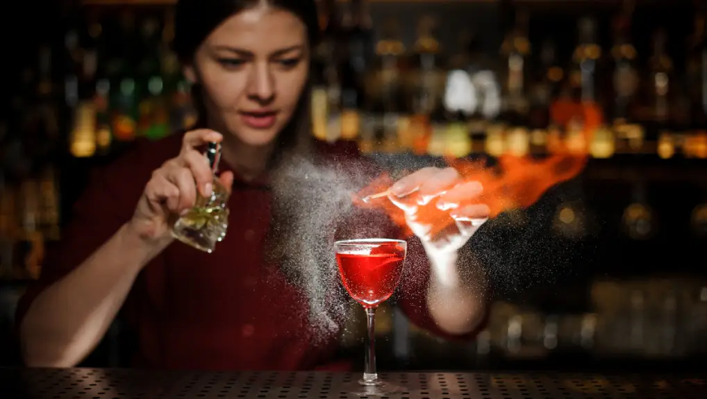 close up image of a bartender displaying presentation skills while making a cocktail