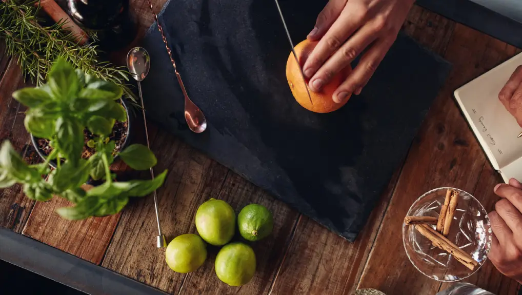 Close up image a over-head shot looking down on a cutting board and bartenders knife.