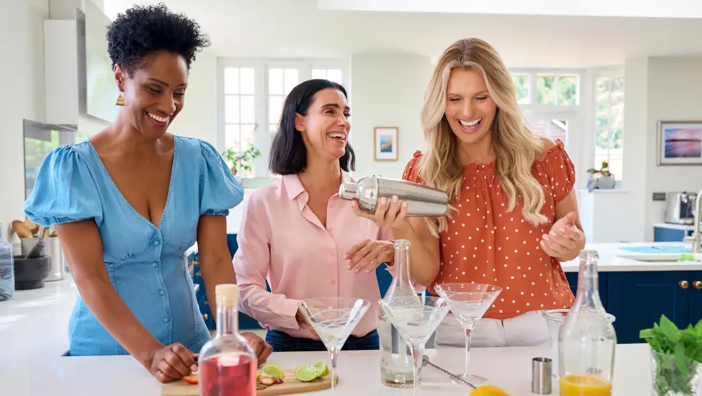 image of 3 women at a home bar making cocktails with bar tools you need to impress your guests